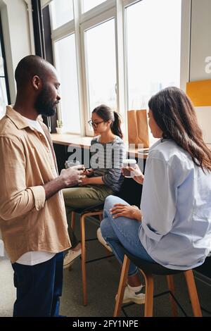 Three young colleagues having a coffee break together Stock Photo
