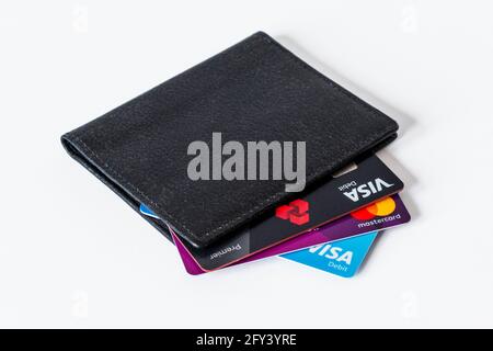 A black leather card holder with credit and debit cards showing, against a white background Stock Photo