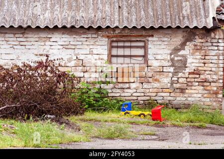 Grungy retro red brick walls with broken gray white stucco. View of the eroded and damaged cracked plaster fence. Vintage wall structure with plaster Stock Photo