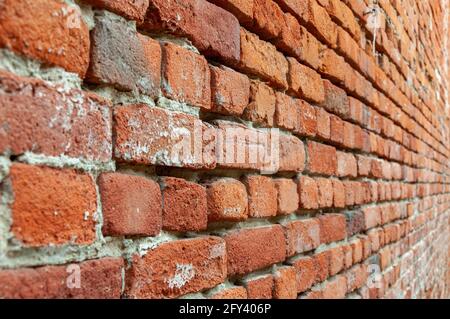 Red Brick Wall With Diminishing Perspective. Fragment of brown brick wall with a shallow depth of field. Angled View Looking Down a Brick Alleyway Stock Photo