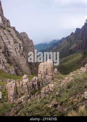 Looking down a remote pass, surrounded by the steep Basalt cliffs, in the Drakensberg Mountains along the Border of South Africa and Lesotho. These ic Stock Photo