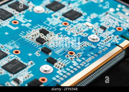 A blue board with chips and a gaming graphics card processor. Progressive cooling system for the video chip, processor and memory. Computer Details Stock Photo