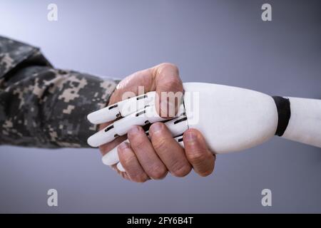 Robot AI Hand Handshake With Military Solider Stock Photo