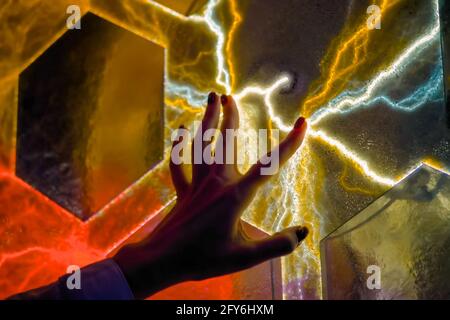 Woman hand touching plasma panel display in dark room of museum - close up view Stock Photo