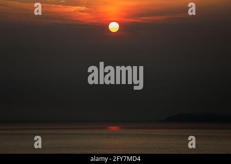 The sun sets over the horizon seen from Anilao in the province of Batangas, south of Manila, Philippines. Stock Photo