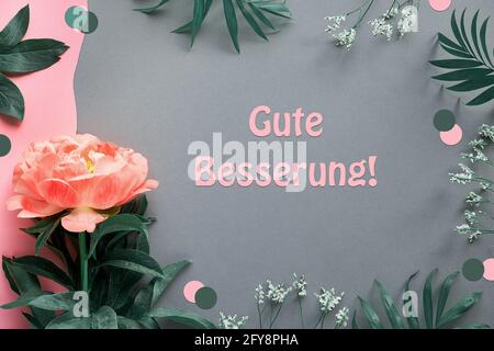 Happy birthday card with peony flower and exotic palm leaves. Single flower on pink and dark grey layered grey paper background. Creative flat lay Stock Photo