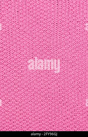 Pink knitted fabric pearl woolen background. The structure of the fabric with a natural texture. Fabric background. Knitted woolen background. Stock Photo