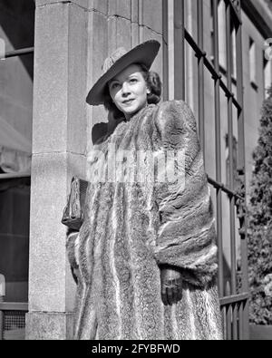 1930s 1940s STYLISHLY DRESSED WOMAN LOOKING AT CAMERA WEARING CHINCHILLA FUR COAT AND FASHIONABLE HAT - f4270 HAR001 HARS LADIES PERSONS SKIN B&W EYE CONTACT CHEERFUL STYLES AND LOW ANGLE SMILES JOYFUL PELT STYLISH CHINCHILLA FASHIONS FURS YOUNG ADULT WOMAN BLACK AND WHITE CAUCASIAN ETHNICITY HAR001 OLD FASHIONED Stock Photo