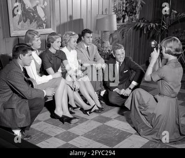 1950s 1960s GROUP OF TEENS SITTING ON COUCH POSING FOR PHOTOGRAPH IN PARTY REC ROOM GIRL KNEELING TAKING PHOTO - j213 HAR001 HARS LIFESTYLE CELEBRATION FEMALES COPY SPACE FRIENDSHIP HALF-LENGTH PERSONS SNAPSHOT MALES TEENAGE BOY B&W SKIRTS DRESSES SCHOOLS SUIT AND TIE CHEERFUL LEISURE UNIVERSITIES REC SEVEN HIGH SCHOOL POSING SMILES HIGH SCHOOLS HIGHER EDUCATION 7 JOYFUL PHOTOGRAPHY STYLISH TEENAGED COLLEGES COOPERATION FLASH JUVENILES POSED TOGETHERNESS BLACK AND WHITE CAUCASIAN ETHNICITY HAR001 OLD FASHIONED PHOTO OP Stock Photo