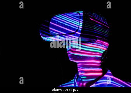 Young woman using virtual reality headset at dark interactive VR exhibition Stock Photo
