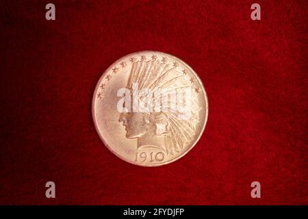 1910s $10 AMERICAN GOLD EAGLE COIN DESIGNED BY AUGUSTS SAINT-GAUDENS SHOWS NATIVE AMERICAN INDIAN HEAD IN WAR BONNET IN PROFILE - ks38500 NAW001 HARS CONCEPTUAL STILL LIFE WAR BONNET HEADDRESS STYLISH NATIVE AMERICAN SAINT-GAUDENS SYMBOLIC CONCEPTS NATIVE AMERICANS SHOWS $10 DESIGNED INDIGENOUS OLD FASHIONED REPRESENTATION Stock Photo