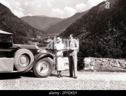 1920s 1930s MAN AND WOMAN PERHAPS LOST READING ROAD MAP STANDING BESIDE AUTOMOBILE NEAR FELDBERG IN BLACK FOREST OF GERMANY  - r3848 HAR001 HARS COMMUNICATION VEHICLE LOST INFORMATION VACATION GERMAN HISTORY FEMALES FOREST MARRIED RURAL SPOUSE HUSBANDS COPY SPACE FRIENDSHIP FULL-LENGTH LADIES GERMANY PERSONS AUTOMOBILE MALES TRANSPORTATION EUROPE B&W PARTNER TIME OFF HIGH ANGLE ADVENTURE EUROPEAN TRIP AND AUTOS GETAWAY TOURIST HOLIDAYS NEAR CONCEPTUAL AUTOMOBILES BESIDE STYLISH VEHICLES COOPERATION MID-ADULT MID-ADULT MAN MID-ADULT WOMAN PACKARD PERHAPS SOLUTIONS TOGETHERNESS VACATIONS WIVES Stock Photo