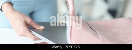 Female hands putting laptop in bag at home closeup Stock Photo