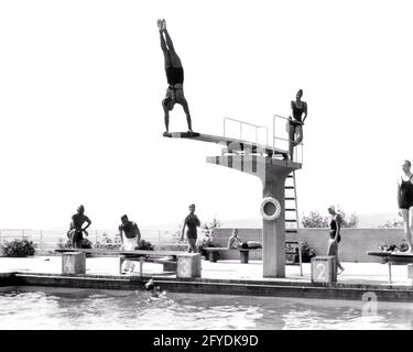 1930s 1935 MAN DOING HANDSTAND ON DIVING BOARD SWIMMING POOL THE OPELBAD IN NEROBERG HILL OVERLOOKING WIESBADEN GERMANY - r6981 HAR001 HARS JOY LIFESTYLE HISTORY FEMALES MARRIED SWIM RURAL SPOUSE HUSBANDS ATHLETICS HILL LUXURY COPY SPACE FRIENDSHIP FULL-LENGTH LADIES PHYSICAL FITNESS GERMANY PERSONS DOING MALES ATHLETIC DIVER B&W PARTNER TIME OFF WIDE ANGLE ACTIVITY SPA PHYSICAL SWIMMING POOL LEISURE STRENGTH TRIP GETAWAY RECREATION DIVING BOARD PRIDE OPPORTUNITY HANDSTAND HOLIDAYS SWIMMERS CONCEPTUAL ATHLETES FLEXIBILITY MUSCLES STYLISH 1935 OVERLOOKING VACATIONS WIVES YOUNG ADULT MAN Stock Photo