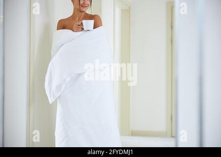 Charming elegant female wrapped in quilt isolated on white background Stock Photo