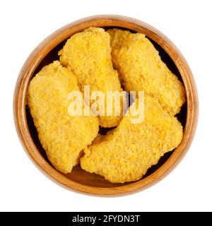 Vegan nuggets, ready to fry, in a wooden bowl. Vegan nuggets, based on soy and wheat protein, in crispy breading, pre-fried and cooked. Close-up. Stock Photo