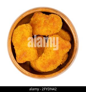 Deep-fried vegan nuggets, in a wooden bowl. Vegan nuggets, based on soy and wheat protein, in crispy breading. Fast food and snack. Close-up. Stock Photo