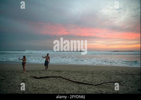 Couple taking a selfie on the beach at sunset at Tamarindo, Costa Rica Stock Photo