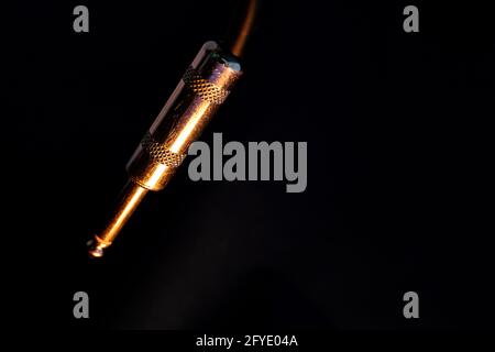 Macro Closeup of Isolated Metal Male Quarter Inch Audio Cable Connector on Black Background Stock Photo