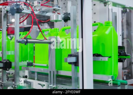 Empty green plastic jerry cans moving on conveyor belt at exhibition Stock Photo