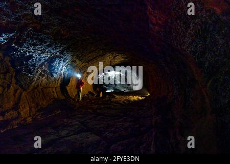 Dinh Quan District, Dong Nai Province, Vietnam - May 22, 2021: A female tourist explores a lava tunnel in Dinh Quan, Dong Nai province, Vietnam Stock Photo