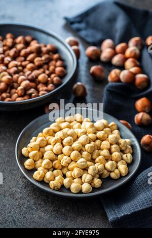 Peeled roasted hazelnut kernels in bowl. Stock Photo