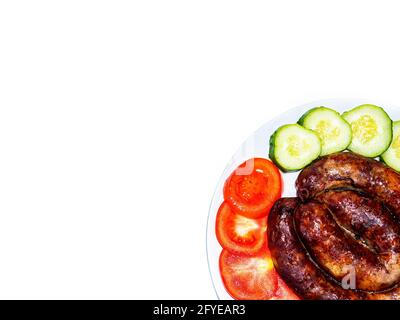 Smoked meat sausage on a plate with tomatoes and cucumbers. Stock Photo