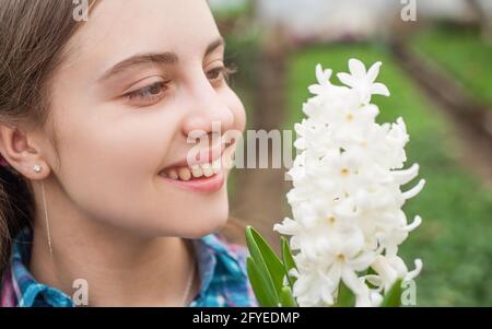 happy teen girl florist care pot plants in greenhouse, flower Stock Photo