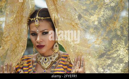 Indonesia Young beautiful woman with Traditional dress standing and look at camera at Gate to heaven Handara Golf Gate in Bedugul, Bali ,Indonesia. Stock Photo