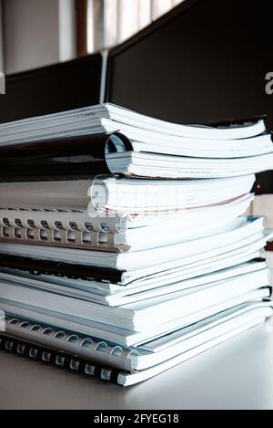 Stack of reports lies on a desk ready for review Stock Photo