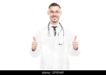 Horizontal medium portrait of successful handsome young adult Caucasian doctor wearing white coat gesturing on camera, white background Stock Photo