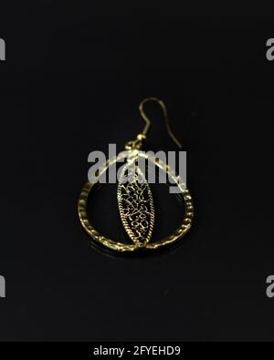 Vertical shot of the gold hoop with a black background. Stock Photo
