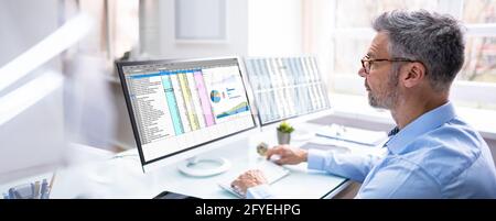 Auditor Employee And Data Analyst Using Computer Spreadsheet Stock Photo