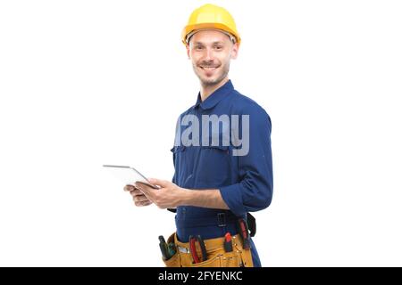 Horizontal medium portrait of successful handsome young adult Caucasian construction engineer wearing uniform using digital tablet, white background Stock Photo