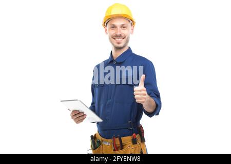 Horizontal medium portrait of successful handsome young adult Caucasian construction engineer wearing uniform using digital tablet, white background Stock Photo