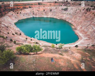 Aerial drone view of young couple of photographers at open mine pit Stock Photo