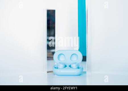 Wireless blue headphones with a white background with two prisms. Stock Photo