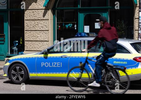 Freiburg, Germany. 05th May, 2021. A cyclist rides past a police emergency vehicle. Credit: Philipp von Ditfurth/dpa/Alamy Live News Stock Photo