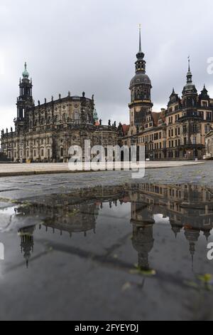 Dresden, Germany. 28th May, 2021. The Hofkirche (l-r), the Hausmannsturm and the Residenzschloss are reflected in a puddle on the Theaterplatz in the old town. Credit: Robert Michael/dpa-Zentralbild/dpa/Alamy Live News Stock Photo