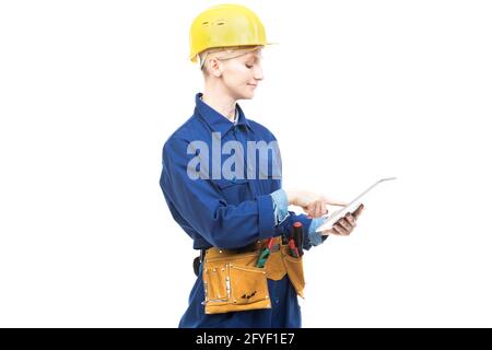 Horizontal medium portrait of modern professional female construction worker wearing blue uniform using digital tablet, white background Stock Photo