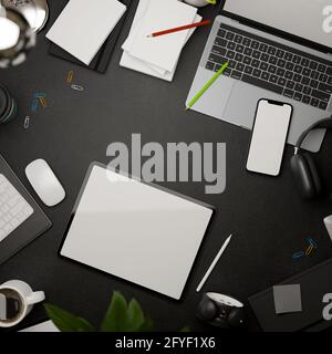 3D rendering, dark creative flat lay workspace with tablet, smartphone, laptop, supplies and copy space on black table, top view Stock Photo