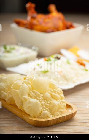 Kerala Papadum or plain pappadom  or Appalam ,arranged in a wooden board  as a side dish for  biryani on wooden textured background,selective focus. Stock Photo