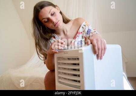 Woman using an air conditioner. Stock Photo