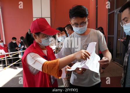 Tangshan, China's Hebei Province. 28th May, 2021. A volunteer helps residents fill out forms at a COVID-19 vaccination site in Tangshan, north China's Hebei Province, May 28, 2021. Credit: Yang Shiyao/Xinhua/Alamy Live News Stock Photo