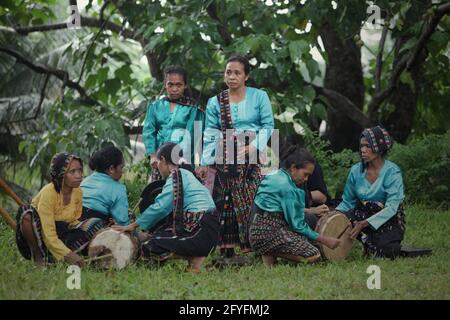 Women playing percussive instruments as musical background for a show of 'caci' (Flores Island's traditional whip fight, martial art) in Liang Ndara village, Mbeliling, West Manggarai, Flores, East Nusa Tenggara, Indonesia. Stock Photo