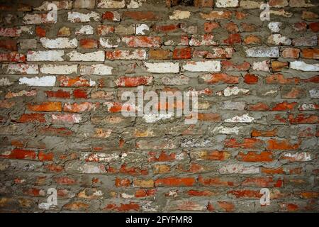 Old brick wall background. Red, orange, yellow and white bricks with gray seams. Stock Photo