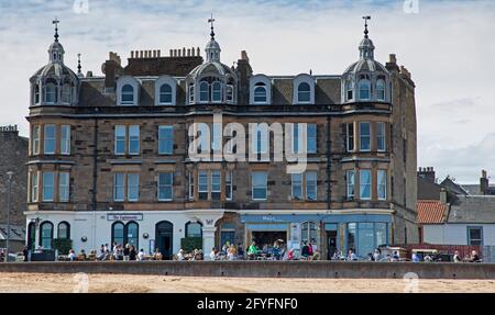 Portobello, Edinburgh, Scotland, UK weather. 28th May 2021. Hazy Sunshine with 14 degrees centigrade at the seaside for those there  to relax and excercise. Pictured: People relaxing at the cafes on the promenade. Credit: Arch White/Alamy Live News. Stock Photo