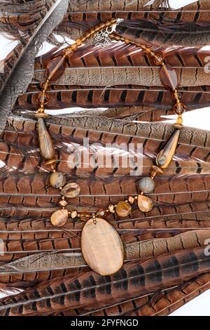 beads from natural stones on feathers Stock Photo