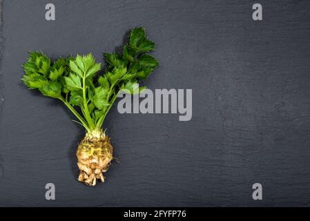 Root of celery, green vegetables on black background, top view, healthy eating, organic food Stock Photo