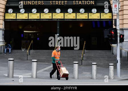 Melbourne, Australia. 28th May, 2021. A man walks past Flinders Street Stationamid the COVID-19 pandemic in Melbourne, Australia, on May 28, 2021. Australia has seen the COVID-19 vaccine doses administered surpass 4 million, almost two months after the government's initial deadline for the target. Credit: Xue Bai/Xinhua/Alamy Live News Stock Photo